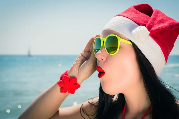 Engraçado jovem mulher em Papai Noel chapéu e óculos de sol — Fotografia de Stock