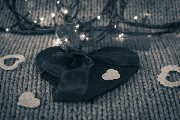 Piccolo cuore decorativo bianco su un grande cuore di feltro con fiocco — Foto Stock