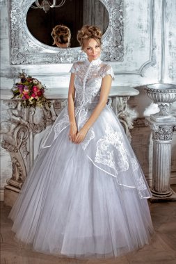 Gelin bir lüks düğün dres şöminenin yanında ayakta