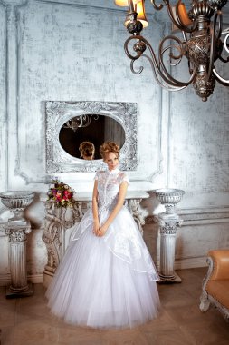 Gelin bir lüks düğün dres şöminenin yanında ayakta