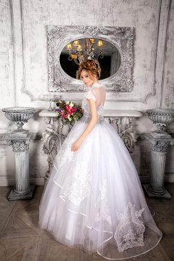 Gelin bir lüks düğün dres şöminenin yanında ayakta