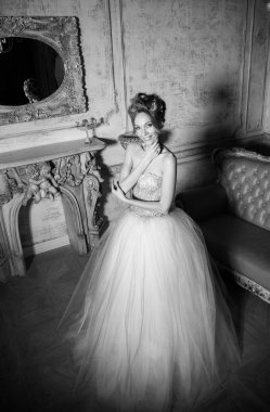 Gelin bir lüks düğün dres şöminenin yanında ayakta