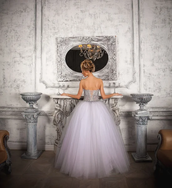 豪華なウェディング ドレスの暖炉のそばに立っている花嫁 ストック画像