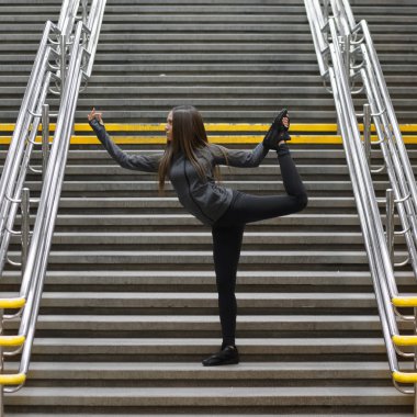 Genç kadın bir kentsel ortamda, bir dizi yoga pozlar çalışma dışarı
