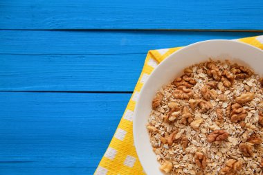 Fındık ile yulaf lapası. Ceviz mavi bir tabloda yulaf ezmesi. Sağlıklı kahvaltı her gün. Üstten Görünüm noktası.