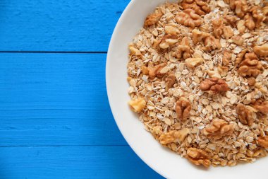 Fındık ile yulaf lapası. Ceviz mavi bir tabloda yulaf ezmesi. Sağlıklı kahvaltı her gün. Üstten Görünüm noktası.