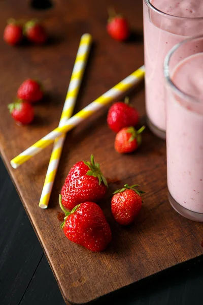 Smoothie de morango e banana no vidro sobre fundo preto — Fotografia de Stock