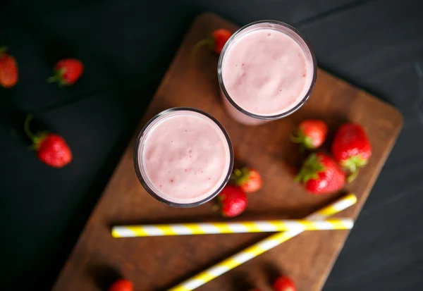 Smoothie de morango e banana no vidro sobre fundo preto — Fotografia de Stock