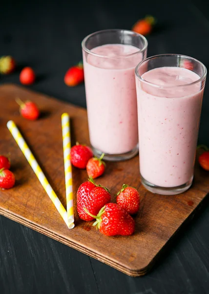 Smoothie de morango e banana no vidro sobre fundo preto — Fotografia de Stock