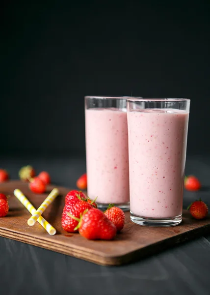 Frullato di fragole e banana nel bicchiere su sfondo nero — Foto Stock