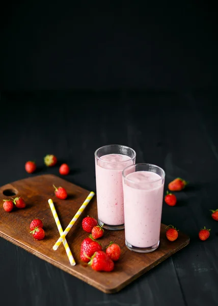 Smoothie de morango e banana no vidro sobre fundo preto — Fotografia de Stock