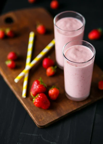 Erdbeer-Bananen-Smoothie im Glas auf schwarzem Hintergrund — Stockfoto