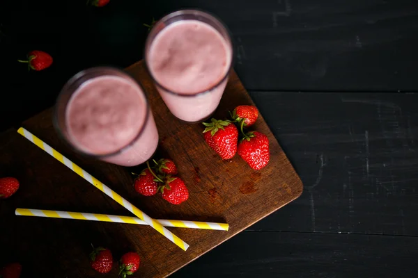 Smoothie de morango e banana no vidro sobre fundo preto — Fotografia de Stock