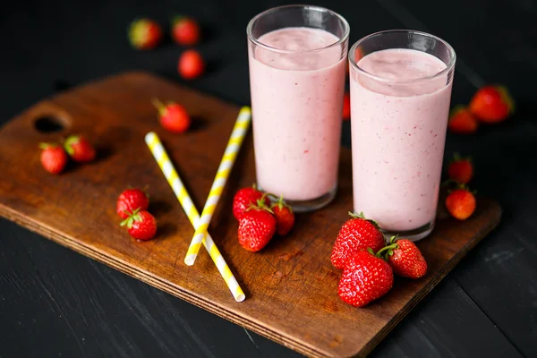 Batido de fresa y plátano en el vaso sobre fondo negro —  Fotos de Stock