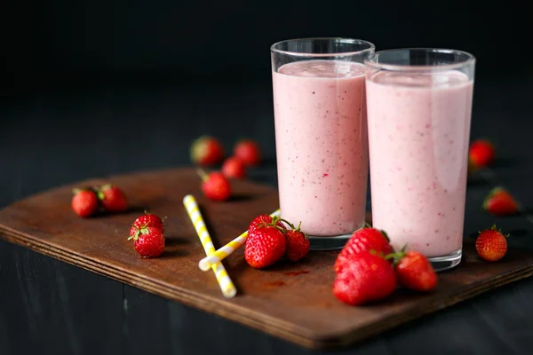 Smoothie aux fraises et bananes dans le verre sur fond noir — Photo