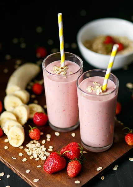 Smoothie de morango e banana no vidro sobre fundo preto — Fotografia de Stock