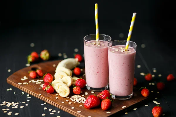 Smoothie truskawek i bananów w szybie na czarnym tle — Zdjęcie stockowe