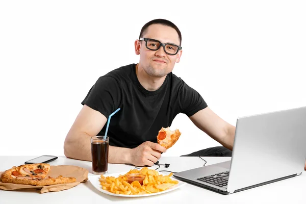 Az ember a számítógépen dolgozik, és gyorséttermi étkezés. Egészségben töltött éveik súlya — Stock Fotó