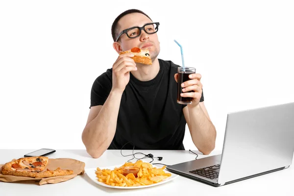 De man werkt op de computer en het eten van fast food. Ongezond leven — Stockfoto