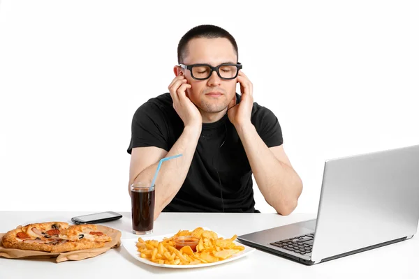 De man werkt op de computer en het eten van fast food. Ongezond leven — Stockfoto