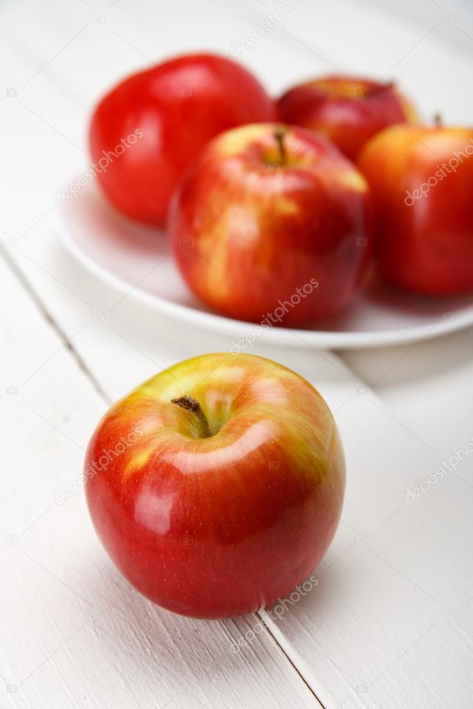 Fresh apples on a white wooden table