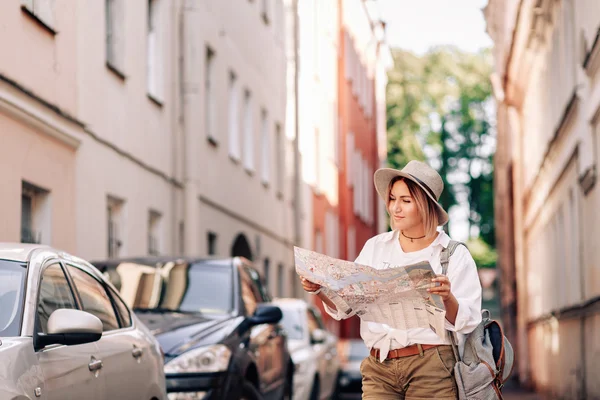 Jovem menina bonita hipster alegre posando na rua no dia ensolarado, se divertindo sozinho, elegante chapéu de roupas vintage. Conceito de viagem — Fotografia de Stock