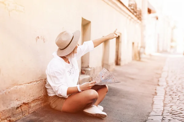 Joven chica bastante hipster alegre posando en la calle en el día soleado, divirtiéndose solo, elegante sombrero de ropa vintage. Concepto de viaje — Foto de Stock