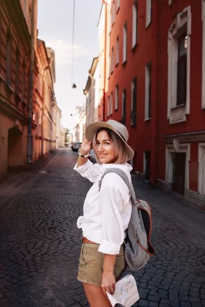 Jonge mooie hipster vrolijk meisje die zich voordeed op de straat op zonnige dag, plezier alleen, stijlvolle vintage kleding hoed. Travel concept — Stockfoto