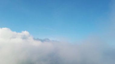 Dağların tepesinde bulutlar arasında uçuyor