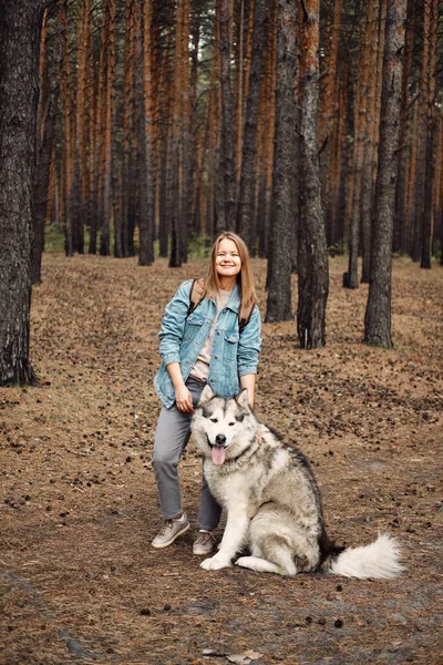 Kvinnlig vandringshund. Ung flicka med sin hund, Alaska Malamute, Utomhus på hösten. Husdjur — Stockfoto
