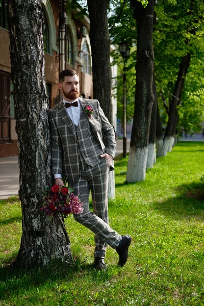 Uomo vestito elegante vestito che tiene Bouquet di fiore — Foto Stock