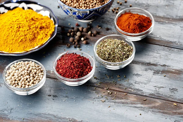 Various spices in bowls on grey table. Powdered spices