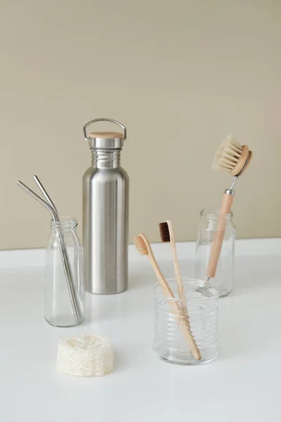 Ecological household goods. Bamboo toothbrushes. Eco-friendly round wooden dishwashing brushes, metal straws, loofah, reusable metal bottle for water and other drinks.