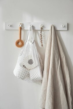 Tuvalet kağıdının olduğu beyaz ip torbası beyaz duvarda. Yeniden kullanılabilir çevre dostu ürünler. Sıfır atık ve sürdürülebilir plastik yaşam tarzı. 