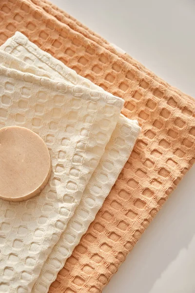 El jabón de oliva natural hecho a mano se encuentra en una toalla de muselina natural. Composición en beige. — Foto de Stock