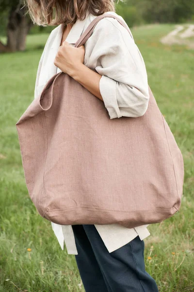 Mooi stijlvol meisje in linnen kleding houdt linnen tas in het bos bij zonsondergang. Geen afval milieuvriendelijk bewust. — Stockfoto