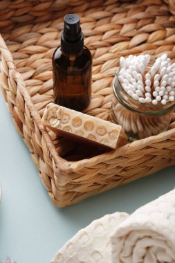Wicker basket contains handmade honey soap with oatmeal, bamboo cotton swabs and a glass bottle. Body care with eco-friendly bathroom accessories. clipart