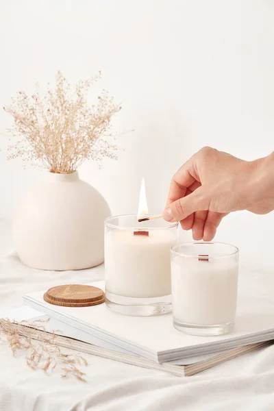 Girl lights soy wax candles with a wooden wick. Handmade candles. — Stock Photo, Image