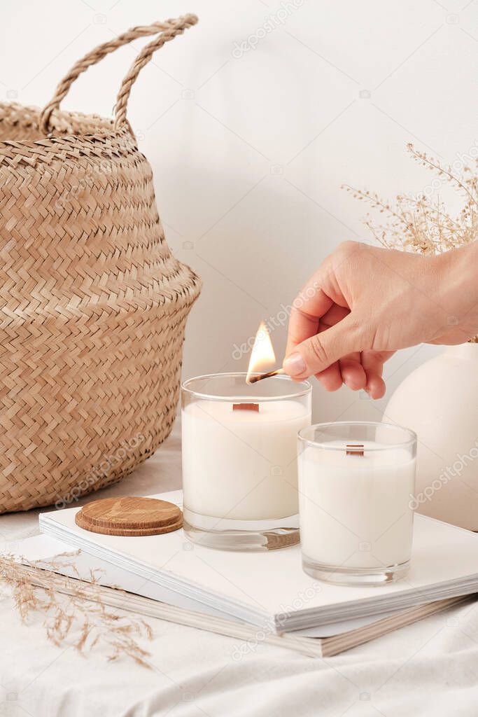 Girl lights soy wax candles with a wooden wick. Handmade candles.
