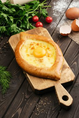 Ahşap servis panosunda Adjarian Khachapuri. Gürcü yemeği. Beyaz ırk.