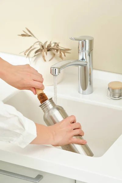 Woman washes a metal reusable bottle with a coconut brush. Washing dishes without chemicals. Woman washes a metal reusable bottle with a coconut brush. Washing dishes without chemicals. — Stock Photo, Image