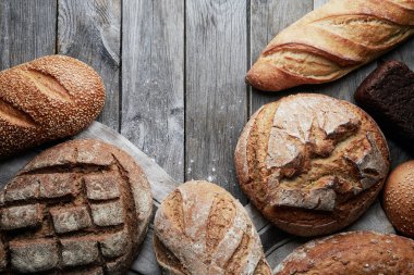 Gri ahşap arka planda çeşitli ev yapımı glütensiz ve mayasız ekmek..