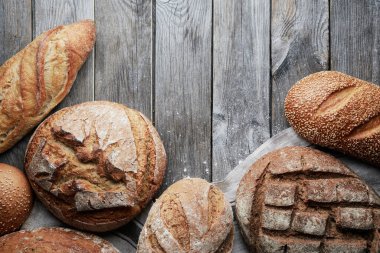 Gri ahşap arka planda çeşitli ev yapımı glütensiz ve mayasız ekmek..