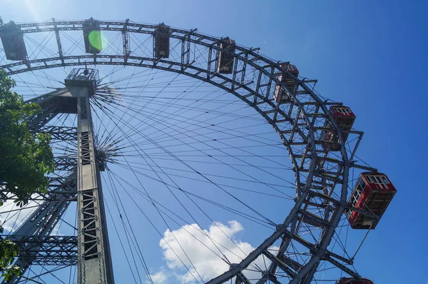 Ferris wiel blauwe lucht wolken en zon — Stockfoto