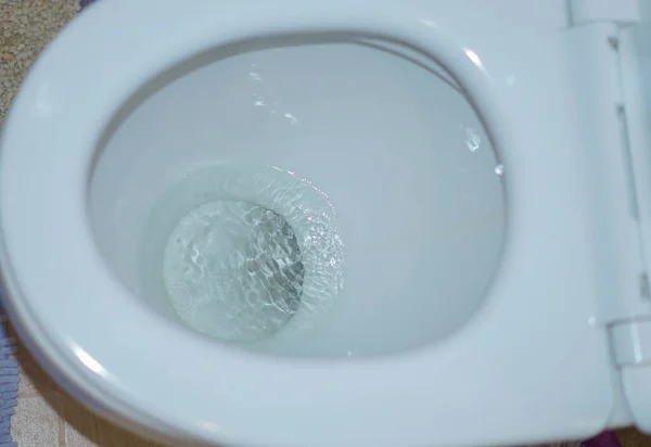 Flushing the water in the white toilet. Close up. — Stock Photo, Image