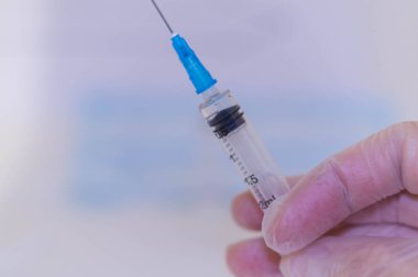 Beyaz arkaplan aşısı Coronavirüs 'e şırınga ile insan eli.