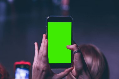 Akıllı telefondan fotoğraf çeken genç bir kadın.