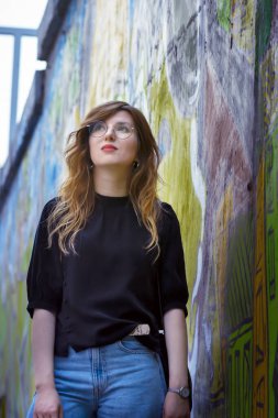 Duvarın arkasında duvar yazısıyla bir kızın portresi.