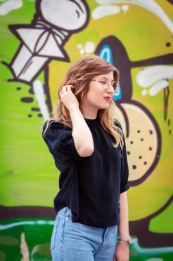 Duvarın arkasında duvar yazısıyla bir kızın portresi.