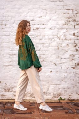 Beyaz tuğlalı duvara dayanmış bir kız